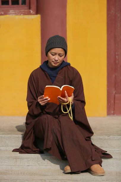 istock A Chinese Nun Reading a book in a temple 1397638246