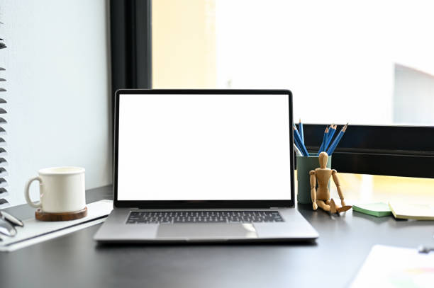 istock Portable notebook laptop computer white screen mockup on modern dark office desk. 1397639552