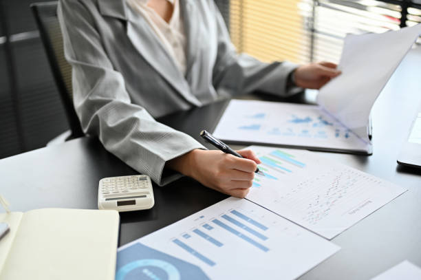 istock Female executive manager in formal suit examining a financial report chart and graph 1397639619