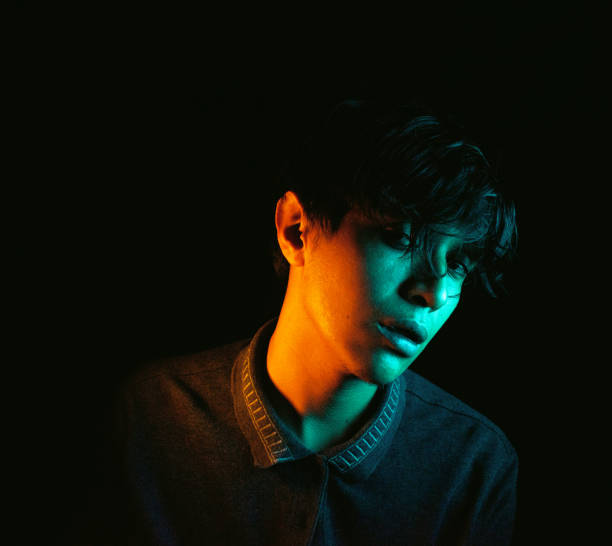 istock Young handsome man on black background with neon lights 1397640293