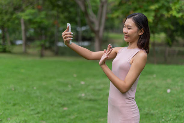 istock Young asian lady chill relaxing and selfie in a park 1397641277