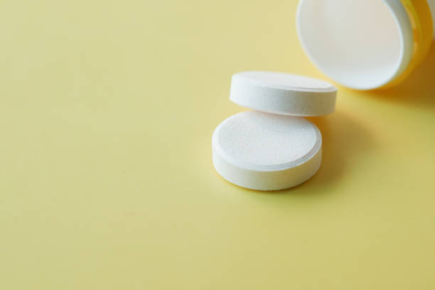 istock Effervescent soluble tablet pills on yellow background 1397647189