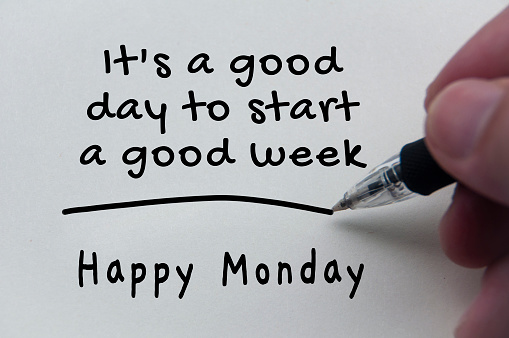 Quotes and text of Happy Monday on notepad.