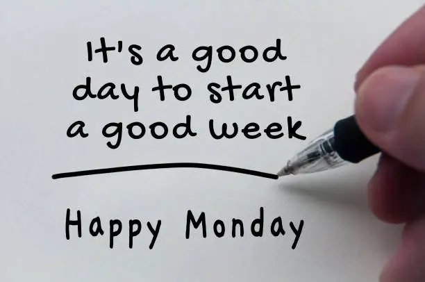 Quotes and text of Happy Monday on notepad.