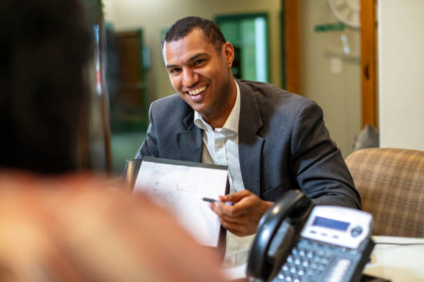 oficial de préstamos masculino estadounidense negro y propietario de una organización sin fines de lucro de mujeres negras que discuten las finanzas de los diversos servicios sociales de ee. uu. - non verbal communication fotografías e imágenes de stock