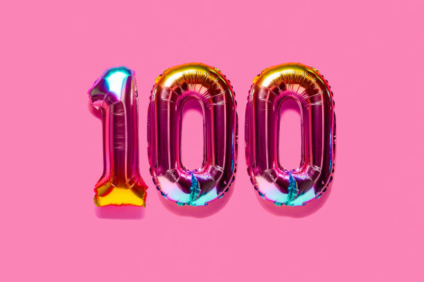 Rainbow foil balloon number. Top view. Rainbow foil balloon number, digit hundred. Top view. Colored numeral on pink background. number 100 stock pictures, royalty-free photos & images