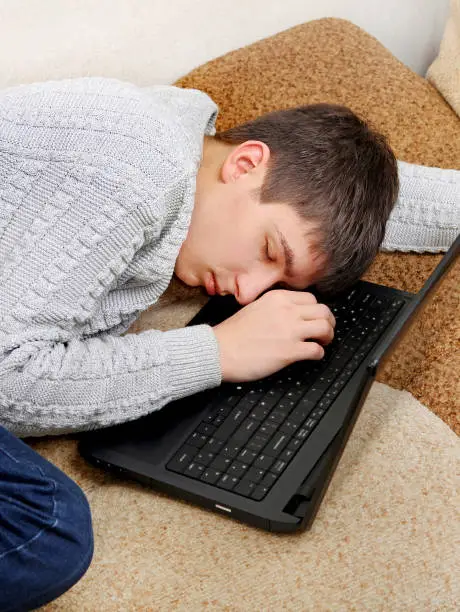Tired Teenager sleep on the Laptop at the Home
