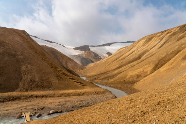 View on steaming hot spring river at Hveradalir  geothermal area against blue sky on sunny day, Iceland