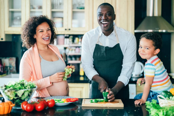 rodzina mieszana rasowo z dzieckiem gotującym w domu - looking at camera two parent family latin american and hispanic ethnicity heterosexual couple zdjęcia i obrazy z banku zdjęć