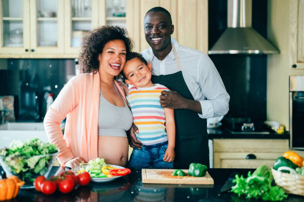 rodzina mieszana rasowo z dzieckiem gotującym w domu - looking at camera two parent family latin american and hispanic ethnicity heterosexual couple zdjęcia i obrazy z banku zdjęć