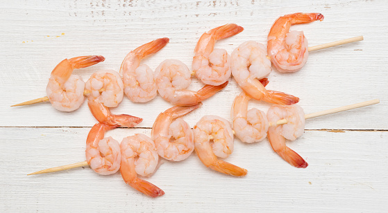 Top view of shrimp skewers on a wooden table