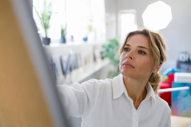 Woman draws or writes on a white flipchart magnetic board