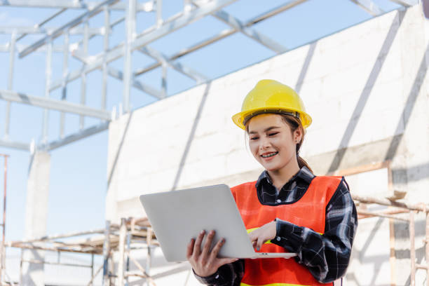istock Asian engineer architect worker woman holding laptop inspect and oversee infrastructure progress at construction site 1397664088