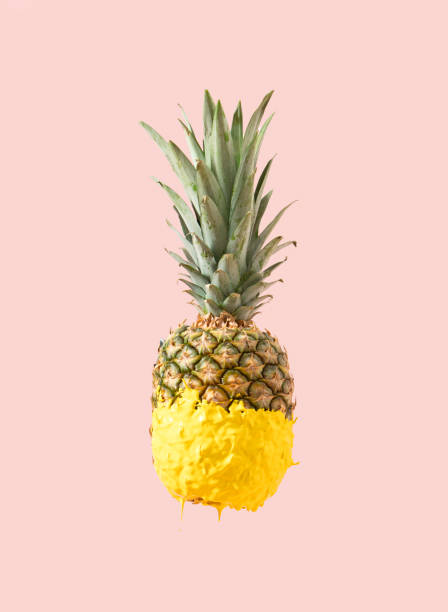 istock Creative Summer pineapple fruit dripped in yellow paint. Tasty refreshing snack for beach party. Pastel pink background. 1397665522