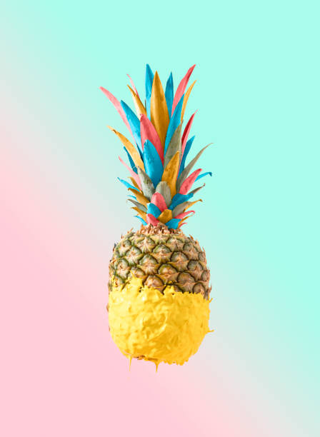 istock Creative Summer colorful pineapple fruit dripped in yellow paint. Tasty refreshing snack for beach party. Pastel pink and blue background. 1397665524