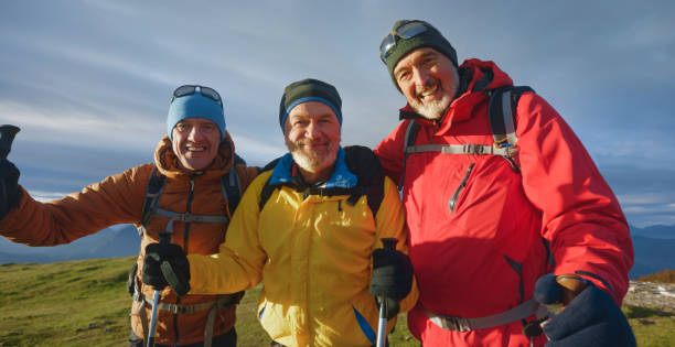 des amis souriants debout contre le ciel - senior adult outdoors wellbeing sky photos et images de collection