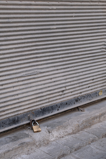 Closed shop shutter and padlock. Economic crises and bankruptcies.