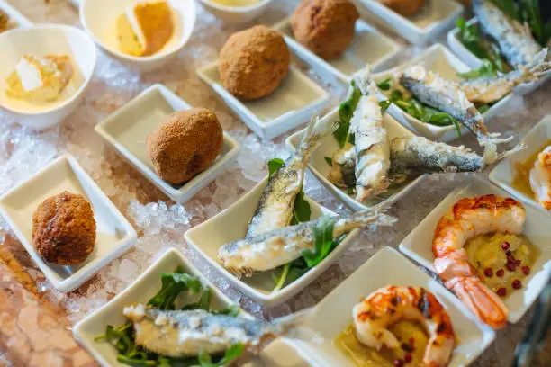 Venetian cicchetti, small dishes as tapas: polpette, Sarde in Saor and shrimps with polenta