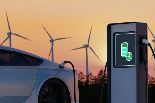 Environmentally friendly electric car charging on background of wind turbines. Evening Sunset view of EV station with port plugged in car. Realistic 3d Rendering of Alternative Energy concept. Renewable energy technologies.