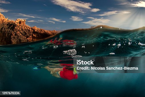istock Woman swimming with a mask and snorkel in the seaGirl snorkelling in the surface of a coast with cliffs 1397670334