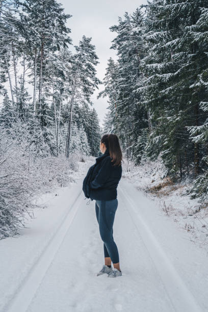 istock Young woman relaxes on snow-covered trail 1397670654
