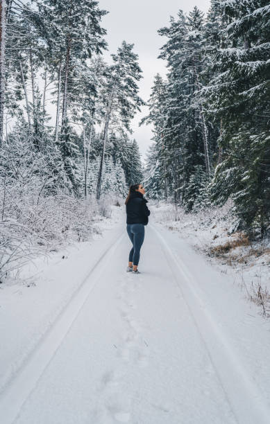 istock Young woman relaxes on snow-covered trail 1397670689