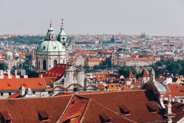 Roofs of Prague with Saint Nicholas Cathedral Roofs of Prague with Saint Nicholas Cathedral st nicholas church prague stock pictures, royalty-free photos & images