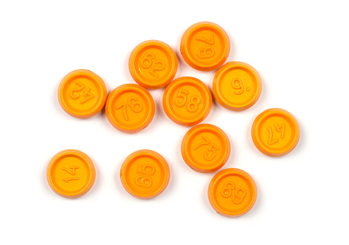 Lotto chips with different numbers on a white background. Orange plastic chips with numbers.