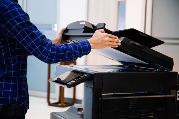 istock Businessmen press button on the panel for using photocopier or printer for printout and scanning document paper at office. 1397675541