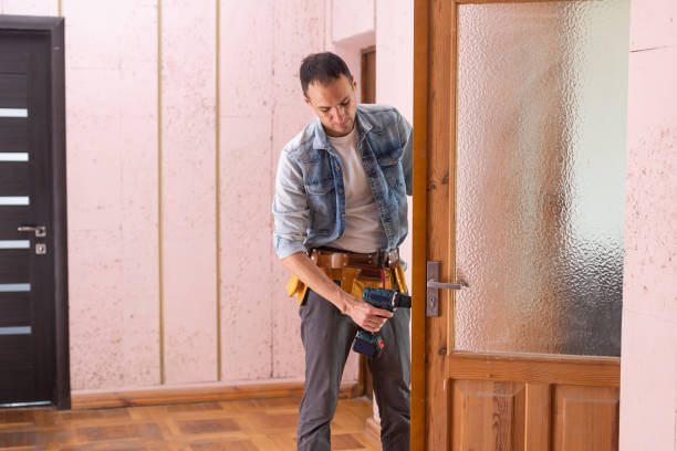 istock Young handyman in uniform changing door lock 1397675622
