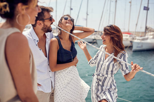 istock A group of young handsome models is having a friendly talk while riding on a yacht through the dock on the seaside. Summer, sea, vacation, friendship 1397675703