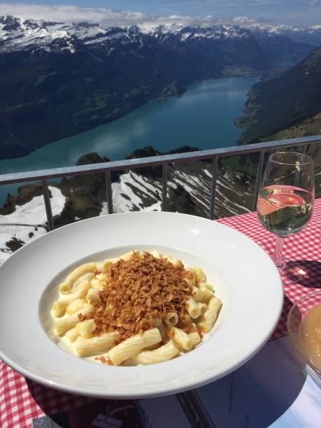 Switzerland - cottage macaroni with fried onions. Typical Swiss mountain dish, served in mountain refreshments, with a panorama of Lake Brienz