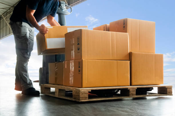 istock Workers Courier Lifting Packaging Boxes on Pallet. Cardboard Boxes. Shipping Supplies Warehouse. Shipment Boxes. Storehouse. Cargo Warehouse Logistics. 1397676383