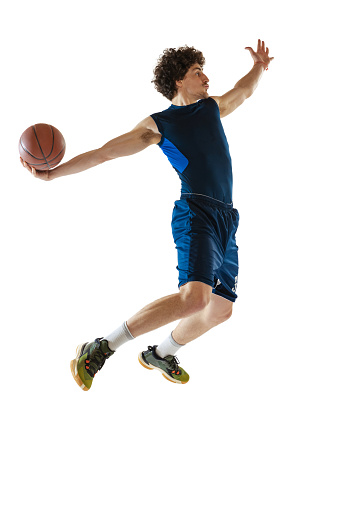 Moves. Dynamic portrait of young man, basketball street player playing basketball isolated on white background. Concept of sport, movement, energy and dynamic, healthy lifestyle. Copy space for ad
