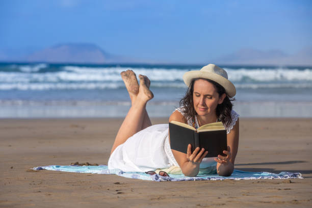 morena curtindo a leitura perto do mar acenando - resting relaxation book break - fotografias e filmes do acervo