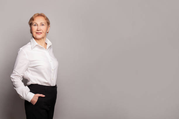 retrato de una hermosa mujer de 60 años con camisa blanca - senior adult 60 65 years people occupation fotografías e imágenes de stock