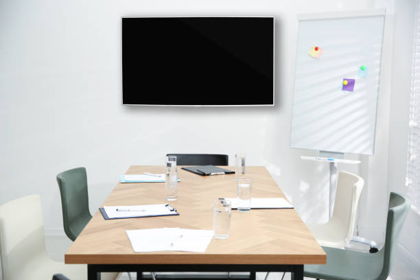 istock Modern wide screen TV on white wall in conference room 1397685103