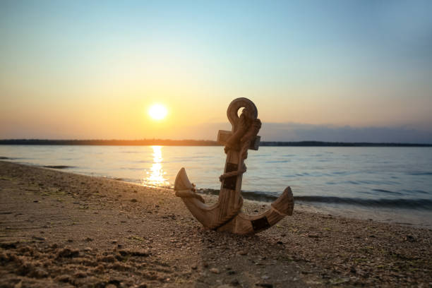 istock Wooden anchor on shore near river at sunset 1397685977
