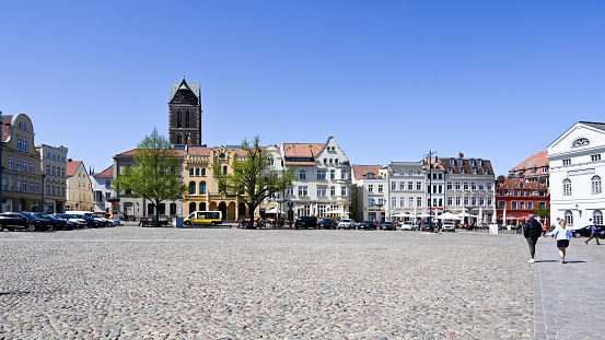 Wismar, Germany, May 8, 2022 - Market square of the historic city center of Wismar, some unidentified people in the background.
