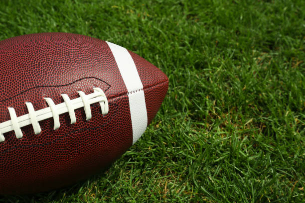 American football ball on green grass, closeup. Space for text American football ball on green grass, closeup. Space for text american football stock pictures, royalty-free photos & images