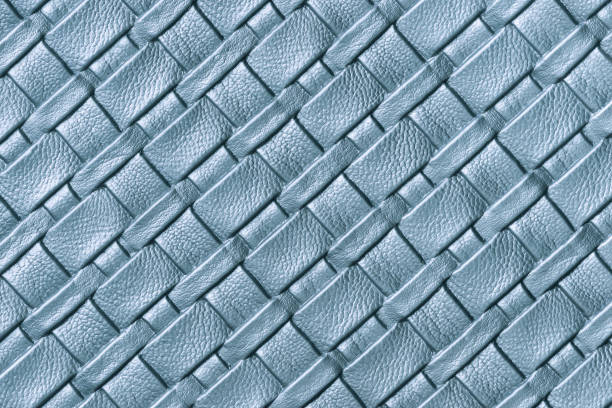 Texture of light blue leather background with wicker pattern, macro. Abstract backdrop from modern decorative denim textile with diagonal lines.