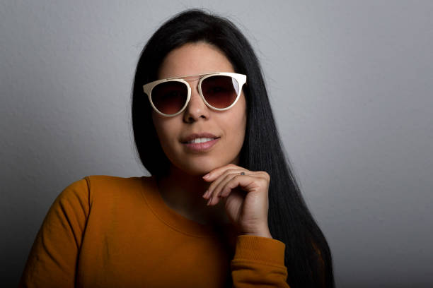 Fashionable sunglasses with round lenses on a dark concrete background