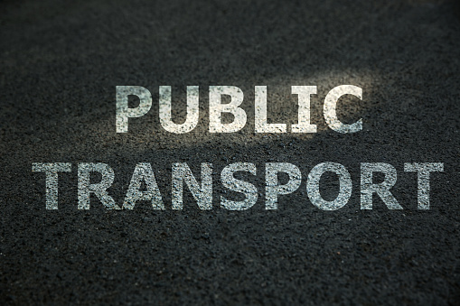 Text PUBLIC TRANSPORT written on asphalt road