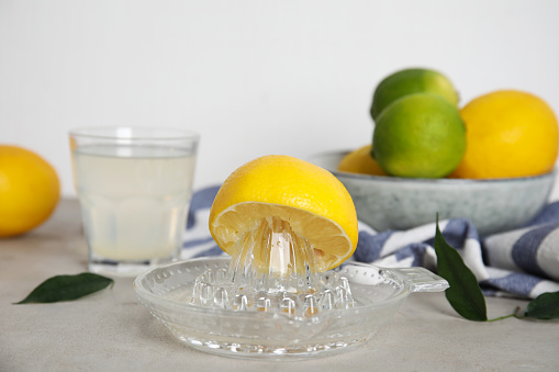 Glass squeezer with lemon and juice on light table