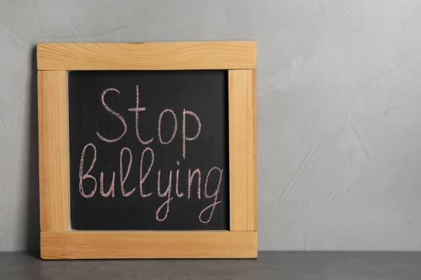 istock Blackboard with phrase Stop Bullying on table near grey wall 1397689984