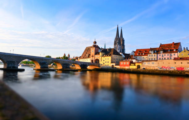 Early morning along the Danube river. View to the cathedral St. Peter and the old stone bridge. Image processing with a miniature effect.
