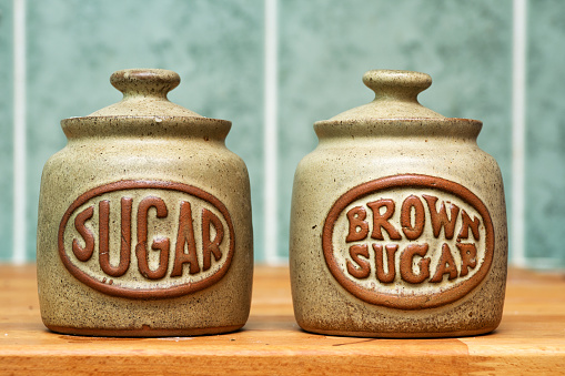 Two Sugar Jars on wooden worktop