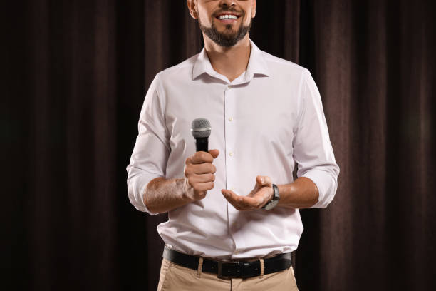 istock Motivational speaker with microphone performing on stage, closeup 1397690146