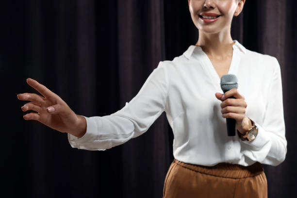 istock Motivational speaker with microphone performing on stage, closeup 1397690148