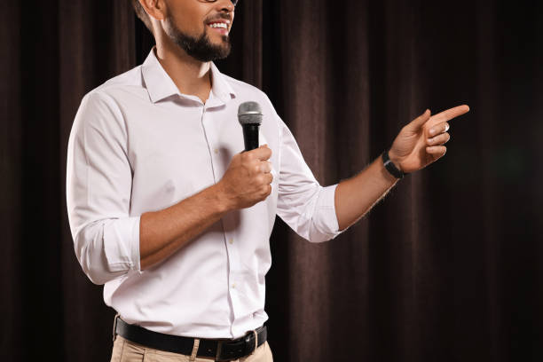 istock Motivational speaker with microphone performing on stage, closeup 1397690709
